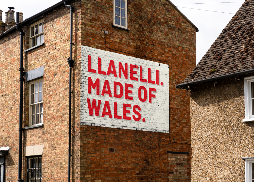 A typographical sign in Llanelli on the side of a building. Painted in white and red.